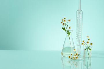 On a blue background, a group of lab glasses, transparent fluid filled in erlenmeyer flasks with...