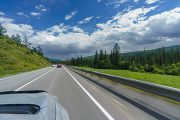 feelings of speed due to smeared roadsides and nature when driving fast on a highway with a blue sky