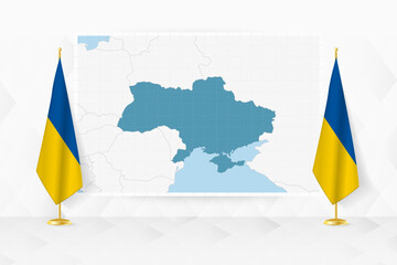 Map of Ukraine and flags of Ukraine on flag stand.