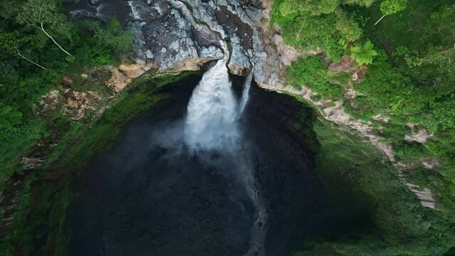 Aerial drone flying back and tilt revealing Coban Sriti waterfall, Indonesia