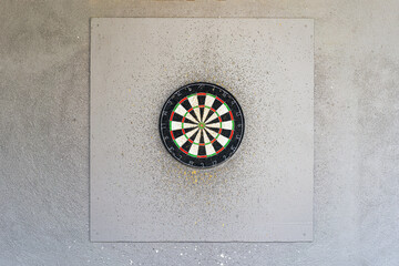 Use classic professional sisal dart board on gray wooden background. Close up