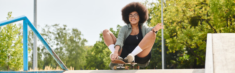 Young African American woman with curly hair enjoying an exhilarating skateboard ride down a ramp...