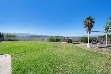 Fototapeta na wymiar Residential backyard with lush grass and trees in Hidden Hills, CA