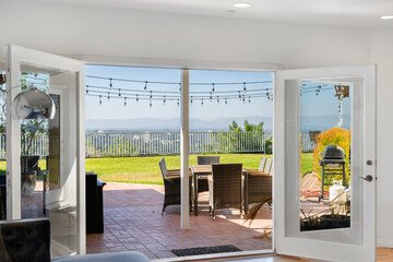 Living room with open patio door and large glass doors in Hidden Hills, CA