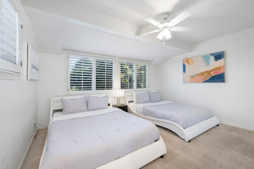 Bedroom interior with two beds, lamps, and a fan in Hidden Hills, CA