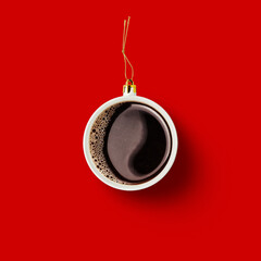 Christmas bauble decoration made of cup of coffee on red background. Minimal concept for Christmas...