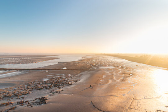 New fertile land and housing for new Dutch residents on Plaat van Walsoorden in the southern region of the Netherlands. Sunrise illuminates the drying areas
