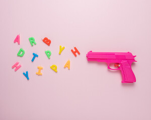 Holiday background with pink gun and birthday candles. Minimal creative concept.