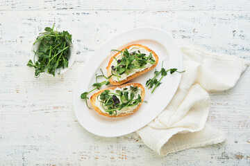Toast or sandwich with cream cheese and micro greens peas and sunflower. Concept healthy food or...
