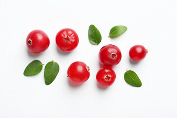 Fresh ripe cranberries and green leaves on white background, flat lay