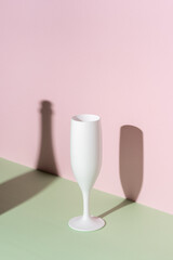 White champagne glass on bright background. Minimal party concept.