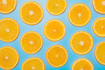 Slices of juicy orange on light blue background, flat lay