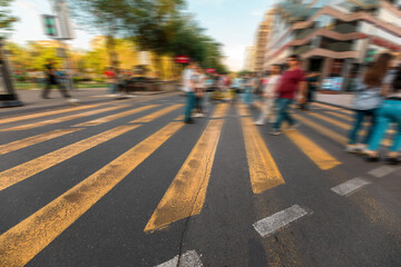 Crossing area, yellow lines, people crossing the road blurred, stock photo
