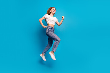 Full length portrait of lovely girl jump run empty space wear top isolated on blue color background