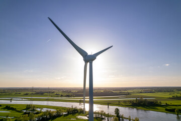 Sun behind wind turbine in The Netherlands part of Dutch sustainable industry along river IJssel...