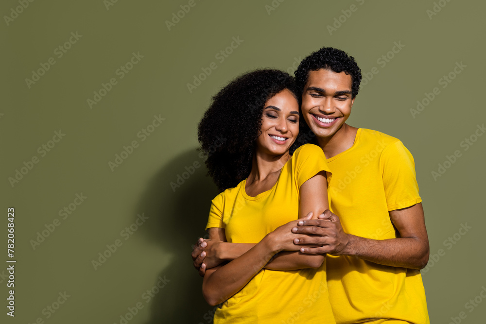 Poster Photo of two young people hug empty space wear t-shirt isolated on khaki color background