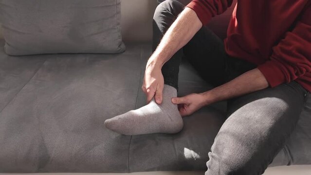 Man with ankle and foot pain at home.