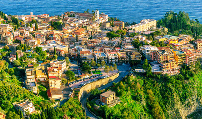 Fototapeta na wymiar scenic view at beautiful mountain town on a sea coast in Italy with green hills, antique buildings and amazing blue sea on backgeound of landscape
