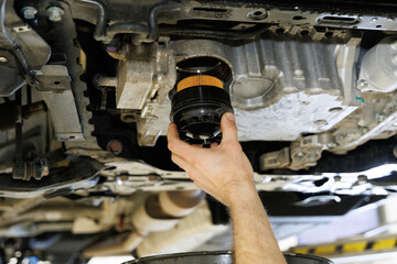 Close up hands of mechanic doing car service and maintenance. Oil and fuel filter changing.Car...
