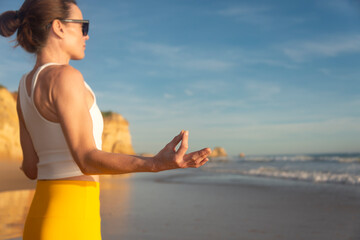 Woman finding inner peace and meditating on a beach.