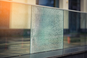 Damaged fence with broken glass, proterty damage. Cracked glass section, broken terrace railings. Damaged glass balustrade. shattered glass fence, damaged shockproof fencing. SELECTIVE FOCUS  