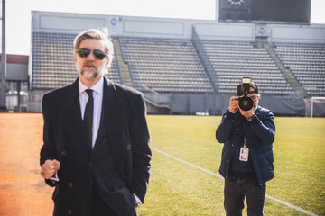 A photographer works at a press conference at the stadium, photographing a politician or the owner...