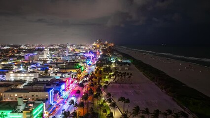 Aerial time Lapse of Miami Beach, Florida Nightlife at Night with colorful lights, clouds, people, and cars.