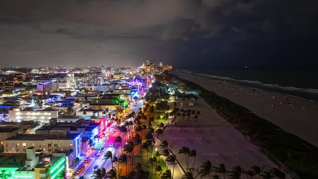 Aerial time Lapse of Miami Beach, Florida Nightlife at Night with colorful lights, clouds, people, and cars.