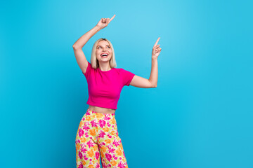 Photo portrait of attractive young woman point look empty space dressed stylish pink clothes isolated on blue color background