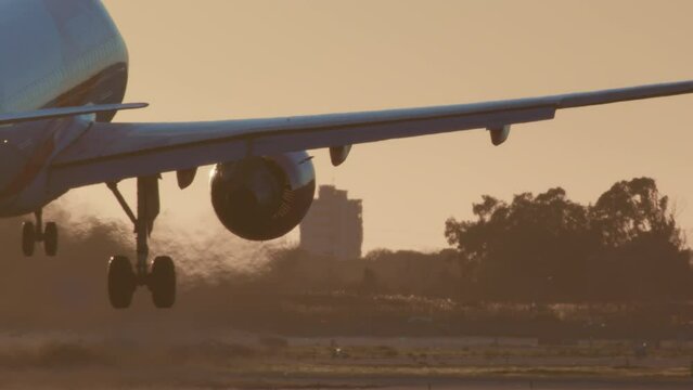 The plane is approaching the runway in slow motion, releasing the landing gear