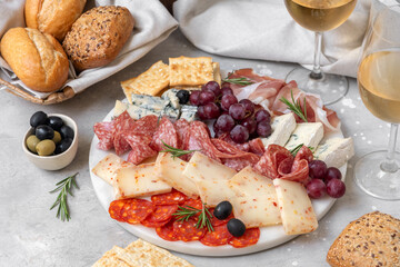 Charcuterie plate with Italian salami and prosciutto ham, with gorgonzola cheese and pecorino cheese with herbs, served with olives and grapes. appetizer platter for aperitif