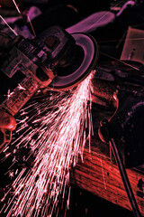 In the hands of a skilled fabricator, a grinder can sharpen, shape or create almost anything.  Sparks fly for this grinding wheel in a grundy and gritty photo from a machinests cluttered workbench.