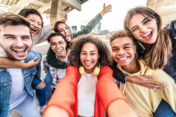 Naklejka premium Happy multiracial friends taking selfie pic outdoors - Group of young people smiling together at camera on city street - University students having fun in college campus - Youth community concept