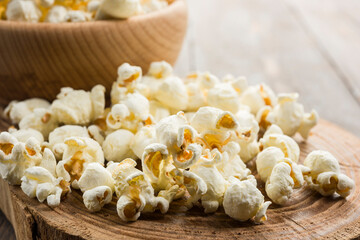 Close up of salted popcorn on wooden table.