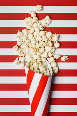 Flat lay composition with popcorn on red and white stripes background.