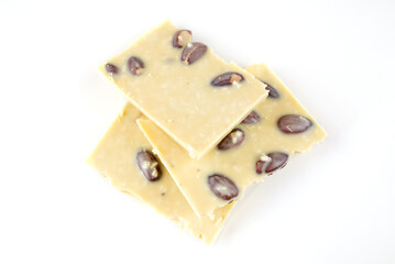 pieces of white chocolate with nuts on a white background.