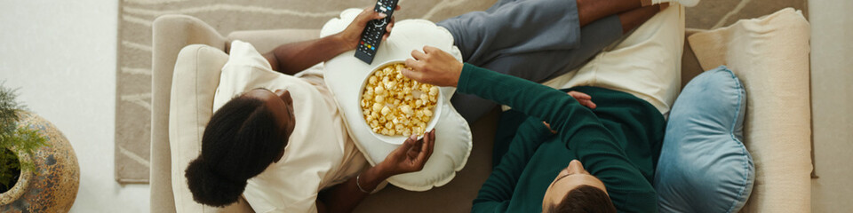 Web banner with couple in love watching show episode on tv at home and eating popcorn