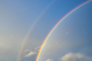 Panoramic view of rainbow with dark clouds over houses after a rainstorm