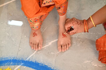 Hand Applying Hindu Swastik on a lag. Swastik As Symbol Of Sun. Hindu Religion. Red ink. Woman...