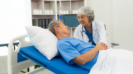Fototapeta premium Senior Asian female doctor examining a sick old man in bed, female therapist caring for grandfather in nursing home Health care and health insurance