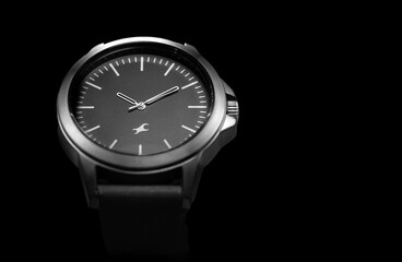 Close up shot of a black and white watch on black background