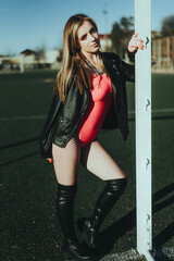 Sexy girl at the stadium in a bodysuit and leather jacket © komokvm