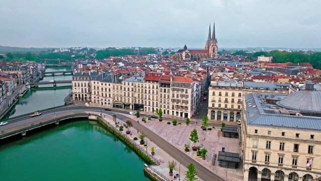 Aerial view of Bayonne city in Basque Country region by the river. Narrow medieval streets and red rooftop buildings. Twin towers rise from hilltop Gothic cathedral with medieval cloisters in France.