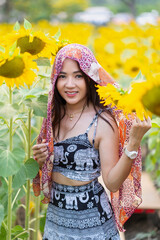 Beautiful Asian girl in sunflower field. Portrait happy young woman posting in sunflower field. Travel ,Summer and Vacation Concept