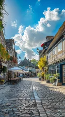 Foto op Canvas A charming village square with cobblestone streets, quaint cafes, and colorful storefronts, against a backdrop of clear blue skies and puffy white clouds © Filip