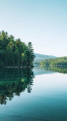 Fototapeta premium lakeside retreat with calm waters, forested shores, and a distant mountain backdrop, under a clear summer sky