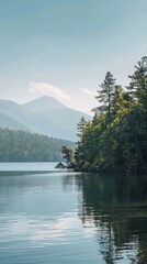 Fototapeta premium lakeside retreat with calm waters, forested shores, and a distant mountain backdrop, under a clear summer sky