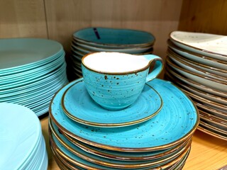 Stack of blue plates and one cup on the top in a store.