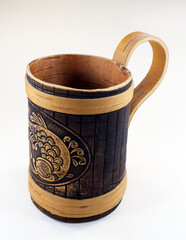 Decorative beer mug made of birch bark with the image of a fish, isolated on white close-up