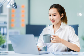In the office, a businesswoman, accountant by profession, works on financial documents. She uses a computer to calculate income, analyze data, and manage budgets. Asian people.
